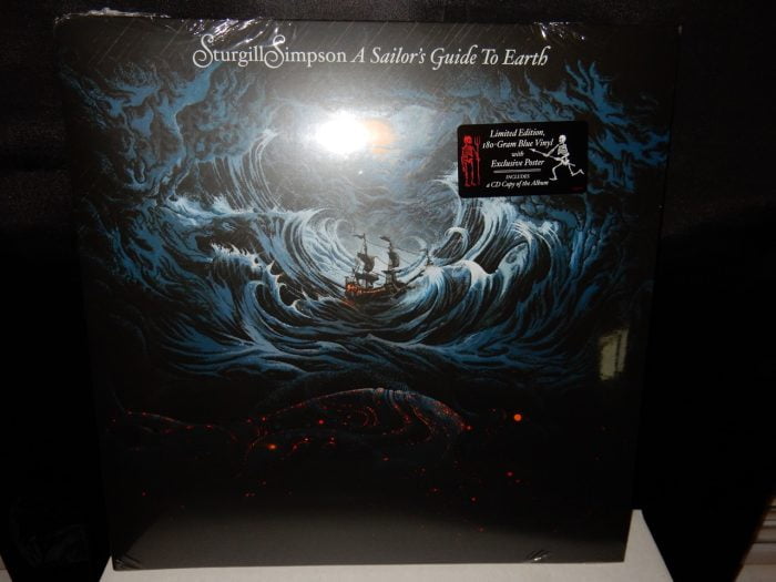 180 gram vinyl LP pressing including bonus CD edition. 2016 release, the third album from the country singer/songwriter. Produced by Simpson, A Sailor's Guide To Earth was written-beginning to end-as a letter to his first child who arrived during the summer of 2014 and features eight original songs as well as a rendition of Nirvana's "In Bloom." Recorded primarily at Nashville's The Butcher Shoppe, Simpson was joined in the studio by Grammy Award-winning engineer David Ferguson (Johnny Cash, John Prine, "Cowboy" Jack Clement) and assistant engineer Sean Sullivan. Along with members of his touring band, the album features Dave Roe on bass, Dan Dugmore on steel guitar, Dougie Wilkinson on bagpipes, Garo Yellin and Arthur Cook on cello, Jonathan Dinklage and Whitney LaGrange on violin and special guests The Dap-Kings. A Sailor's Guide To Earth follows his break-through, Grammy-nominated 2014 release, Metamodern Sounds In Country Music. Beloved by critics and fans, the record was featured on year-end "best of" lists at The New York Times, Rolling Stone, the Village Voices' Pazz and Jop, Rolling Stone Country, NPR Music, American Songwriter, Stereogum, the Los Angeles Times, KCRW, Pitchfork, The Washington Post and many others.